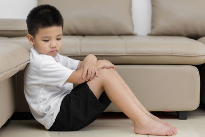 Boy sitting on sofa at home