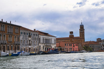 Buildings in city against cloudy sky