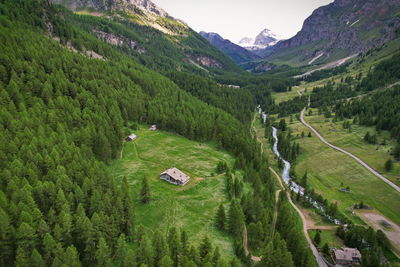 An isolated mountain cottage in the woods seen from above