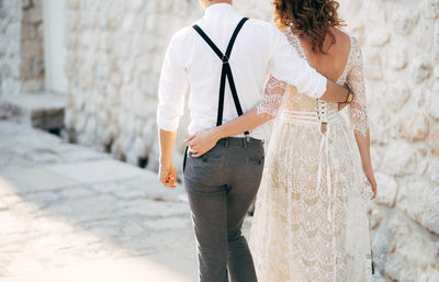 Rear view of woman standing against white wall