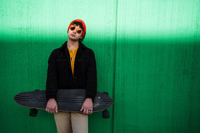 Portrait of woman standing against wall