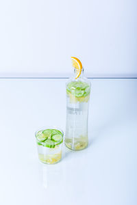 Green fruits on glass against white background