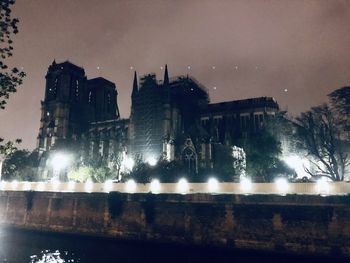 Low angle view of illuminated buildings against sky at night