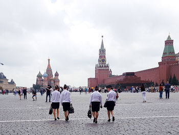 Group of people in front of building against sky