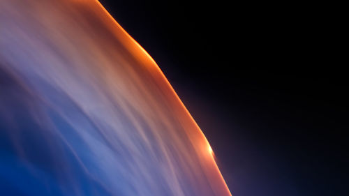 Low angle view of illuminated light against sky at sunset