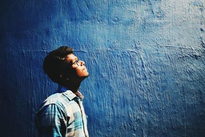 Close-up of man against blue wall