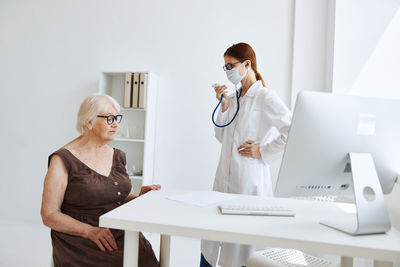 Woman using phone while sitting on table