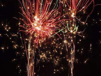 Low angle view of firework display at night