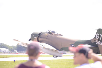 Man photographing airplane against clear sky