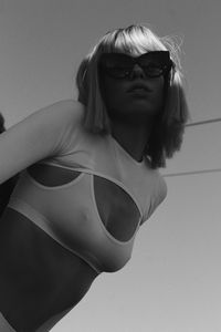 Portrait of young woman standing against wall