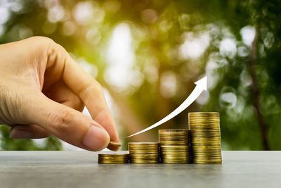 Cropped image of hand holding coin stack