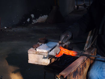 Cropped image of craftsperson working on hot metal