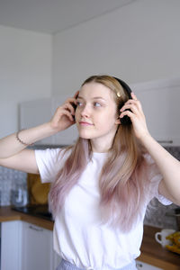 A cute caucasian teen girl listening music with wireless headphones