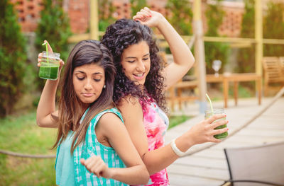 Friends dancing while having drink at restaurant