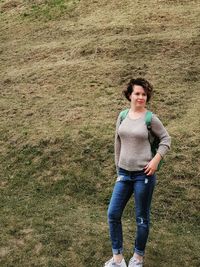 Portrait of young woman standing on field