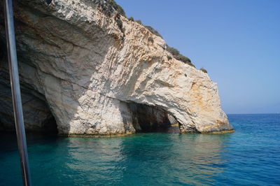 Rock formation in sea against sky