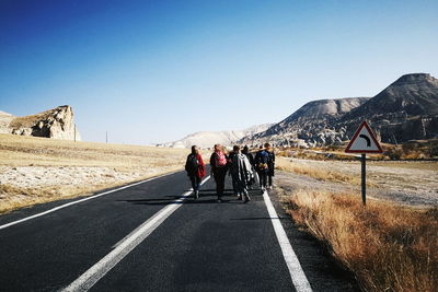 Rear view of people on road