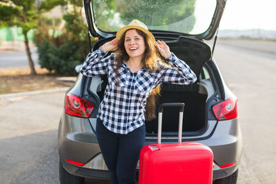 Portrait of woman wearing sunglasses on car