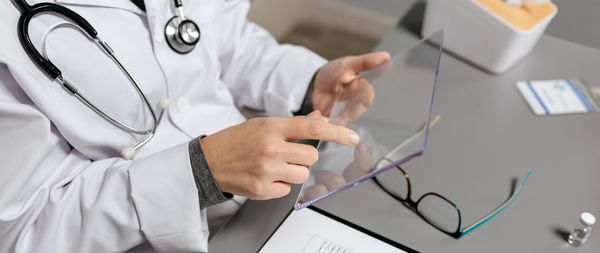 Midsection of doctor examining patient in hospital