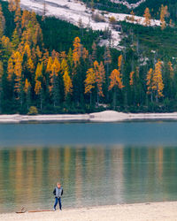 Person on lake by trees in forest