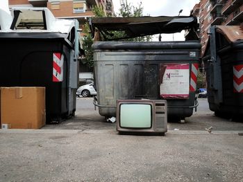 Garbage bin by street in city