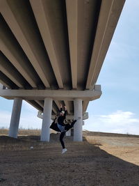 Full length of woman standing on bridge against sky