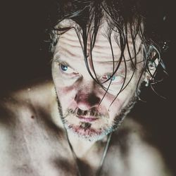 Close-up portrait of a man against black background