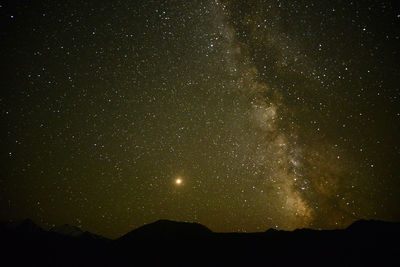 Low angle view of silhouette mountain against sky at night