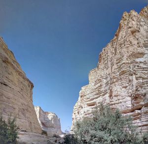 Low angle view of rock formation against clear blue sky