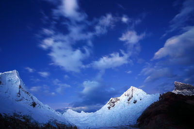 Scenic view of snowcapped mountains against cloudy sky