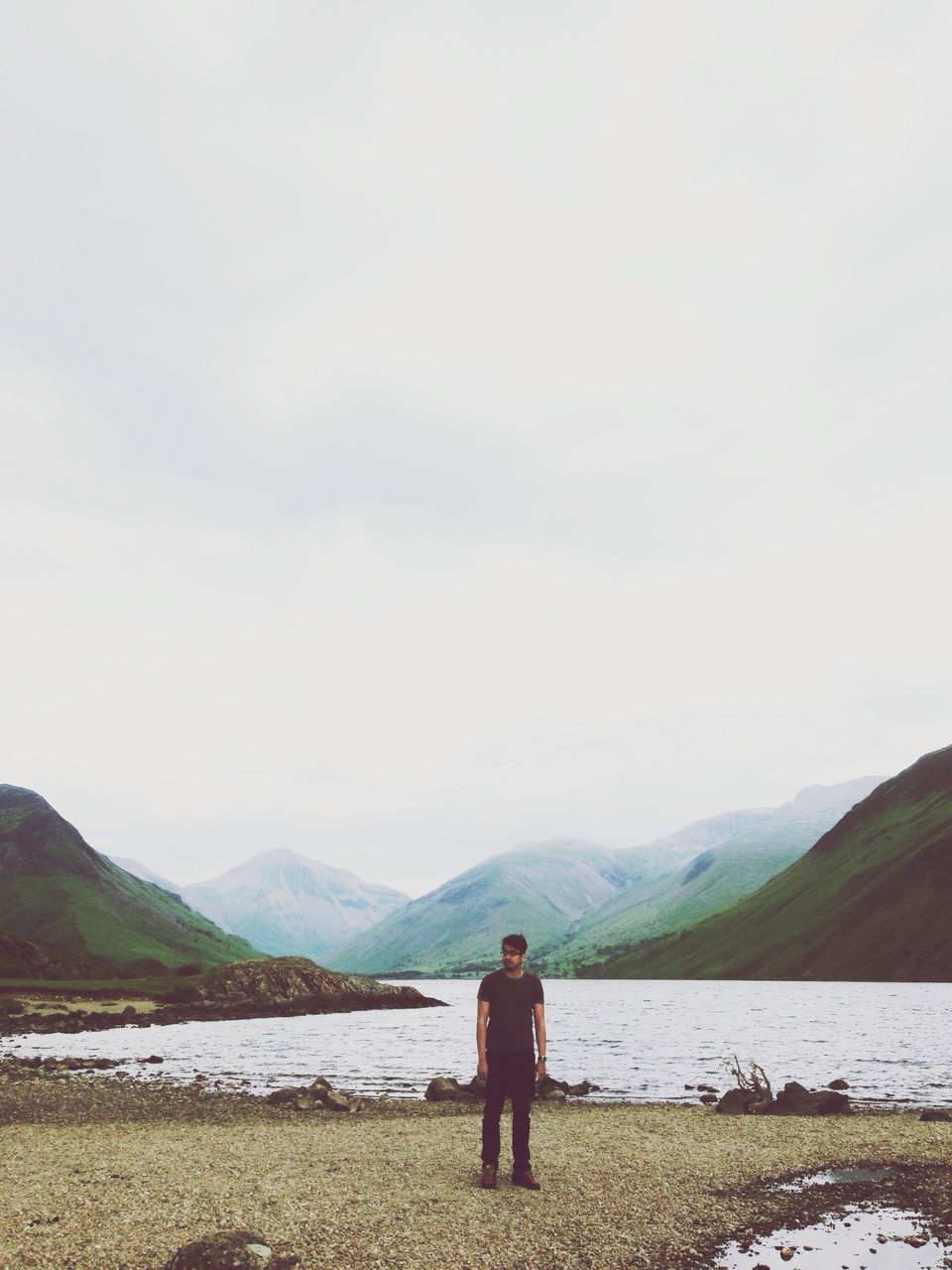 water, mountain, rear view, lifestyles, leisure activity, tranquil scene, tranquility, lake, scenics, full length, mountain range, standing, beauty in nature, sky, nature, looking at view, beach, shore