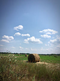 Hay bales on field against sky