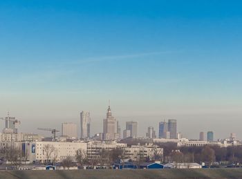 Modern buildings in city against blue sky