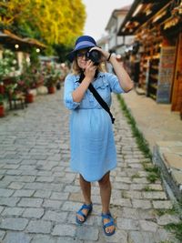 Full length of woman standing on footpath