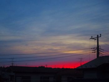 Low angle view of silhouette electricity pylon against sky during sunset