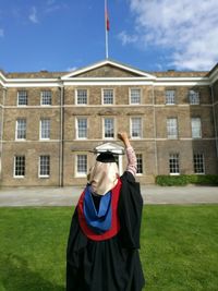 Rear view of woman in graduation gown at university of leicester