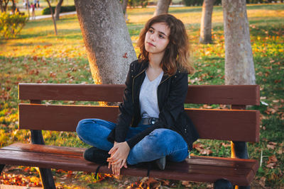 Young woman sitting on bench at park