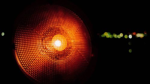 Close-up of illuminated electric lamp against black background