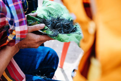 Midsection of woman holding hair in leaf