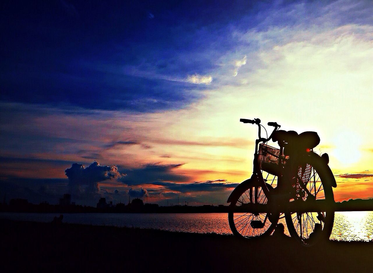 sunset, silhouette, sky, water, sea, cloud - sky, horizon over water, scenics, tranquility, beauty in nature, tranquil scene, bicycle, orange color, nature, dusk, idyllic, cloud, railing, outdoors, cloudy