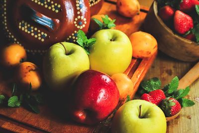 Fruits arranged on a wooden cutting board wrapped in a warm light