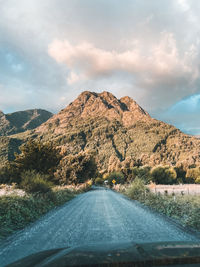 Road amidst mountains seen through car windshield