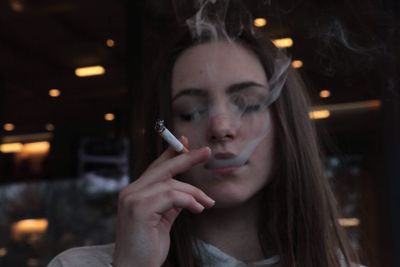 Close-up of young woman smoking cigarette