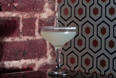 Close-up of drink on table against wall