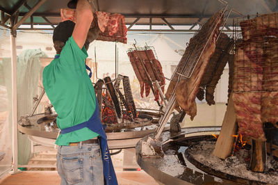 Side view of mature man preparing food in kitchen