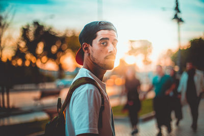 Portrait of young man in city against sky