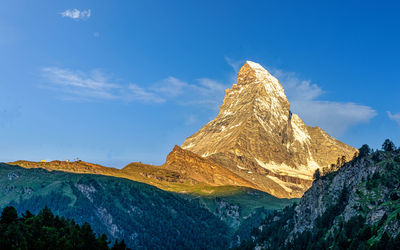 Scenic view of mountains against blue sky