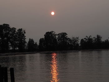 Scenic view of lake against clear sky during sunset
