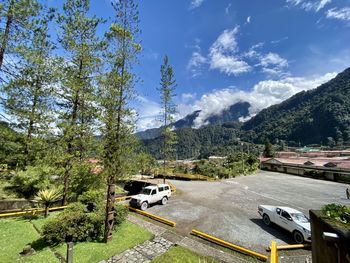 Road by plants and mountains against sky