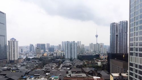 Aerial view of buildings in city against sky